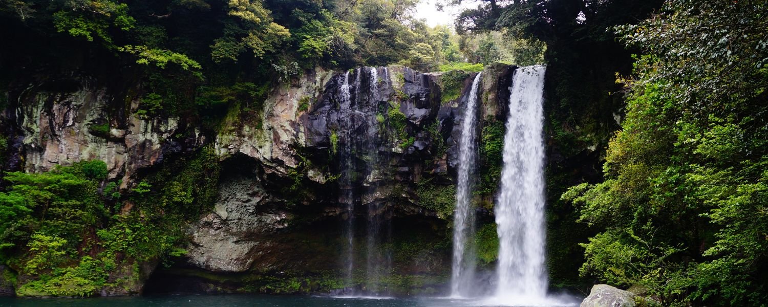 Captivating view of the majestic Karkat Waterfall, as crystal-clear water cascades down a lush green cliff, creating a mesmerizing spectacle of nature's beauty.l